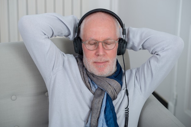 Senior homme écoutant de la musique à la maison