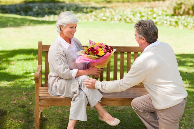 Senior homme offrant des fleurs à sa femme