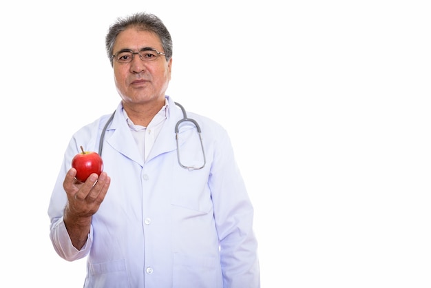 Senior homme persan médecin tenant pomme rouge