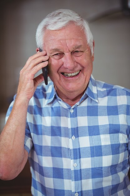 Senior homme souriant au téléphone