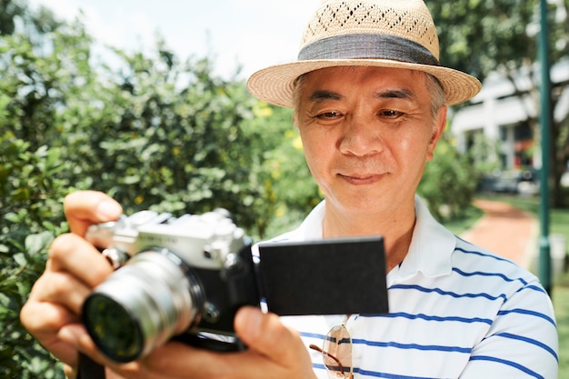 Senior homme vérifiant les photos à la caméra