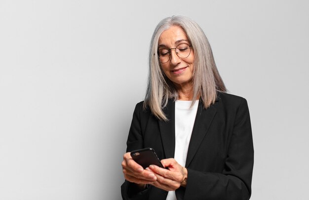 Senior jolie femme d'affaires avec un téléphone intelligent.