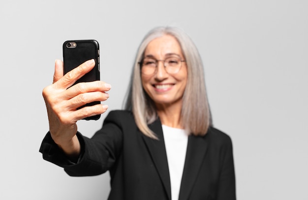 Senior jolie femme d'affaires avec un téléphone intelligent.