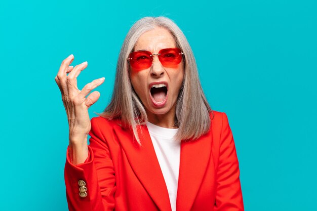 Senior jolie femme avec des lunettes de soleil rouges