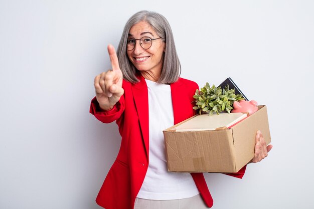 Senior jolie femme souriante et sympathique, montrant le numéro un. notion de licenciement