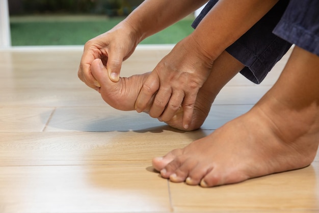 Photo senior man masser le pied avec une inflammation douloureuse de la goutte enflée