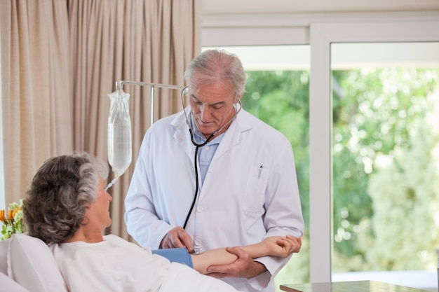 Senior médecin prenant la tension artérielle de son patient