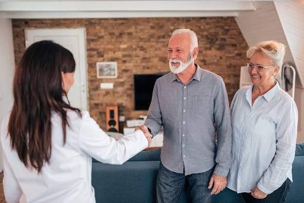 Senior patient souriant et médecin se serrant la main.