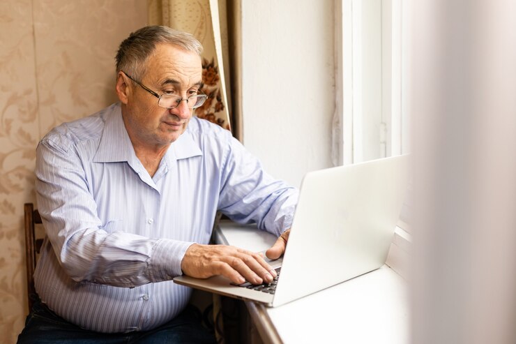 Senior travaillant sur un ordinateur portable à la maison