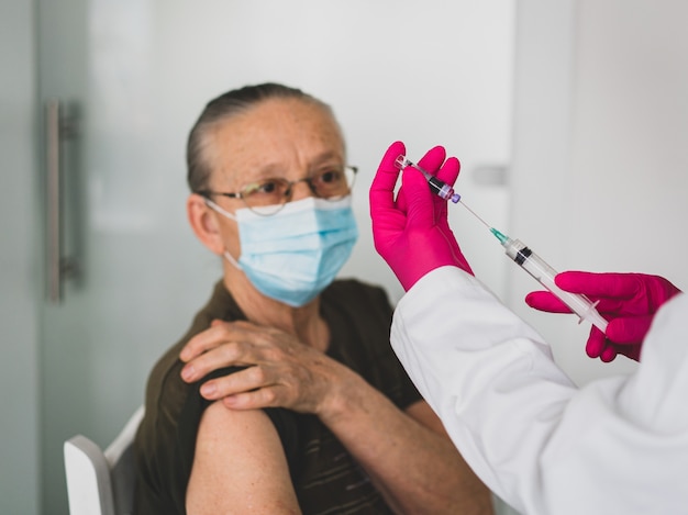 Senior vieille femme à l'hôpital se faire vacciner