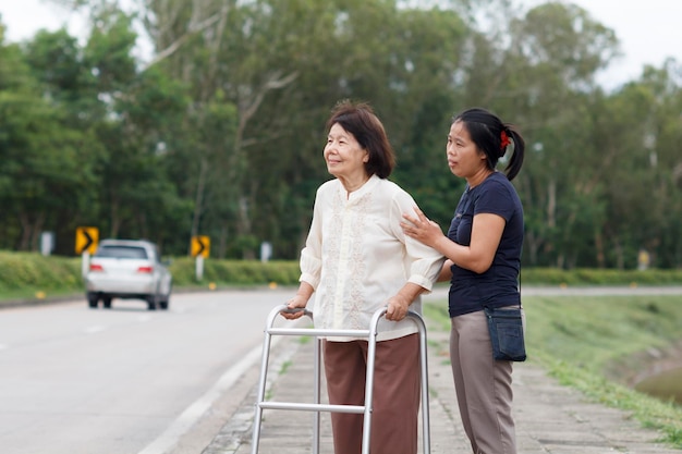 Senior woman à l'aide d'un walker cross street