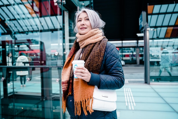 Senior woman attend le train à la gare