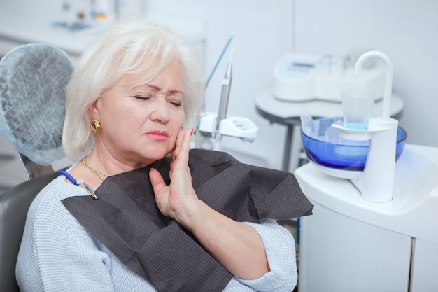 Senior woman ayant mal aux dents, dentiste de visite