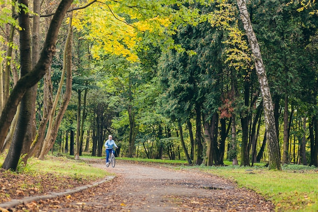 Senior woman dans le parc avec un vélo