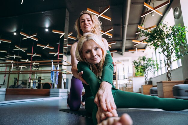 Senior woman doing phisycal réadaptation et pilates avec son entraîneur dans le centre sportif