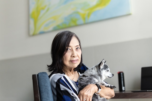 Senior woman holding mignon petit chien chihuahua