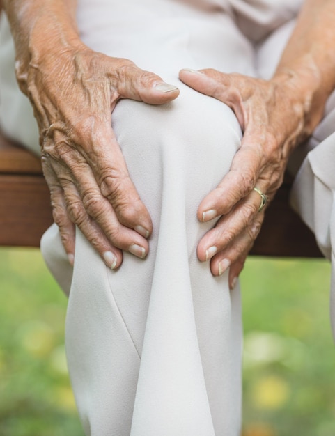 Senior woman holding son genou douloureux