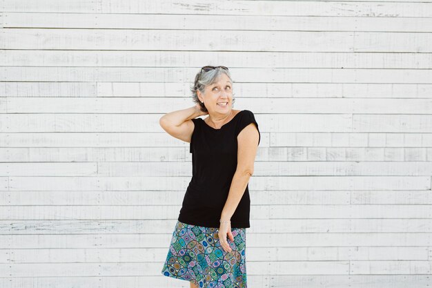 Senior woman making grimace sur une surface blanche