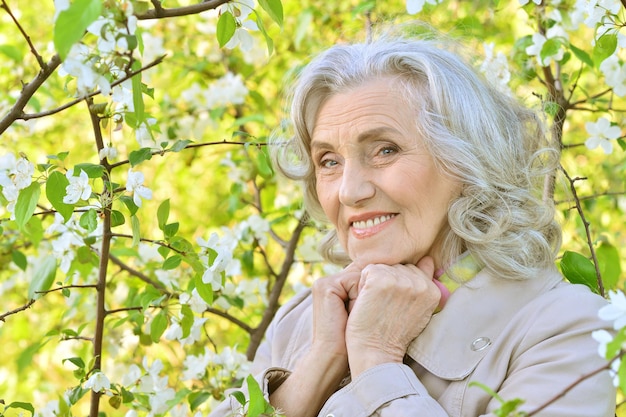 Senior woman près de l'arbre en fleurs