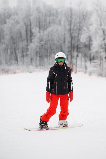 Senior woman ride sur stand de snowboard en montagne d'hiver
