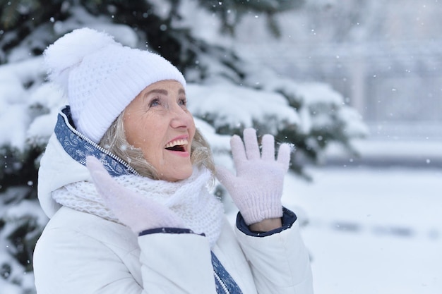 Senior woman rire et se réjouir en hiver neigeux