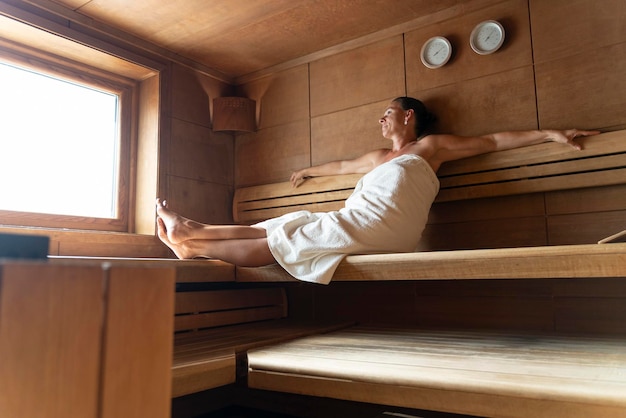 Senior woman sitting détendu dans un sauna en bois