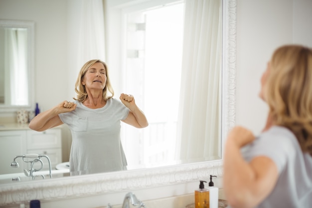 Senior Woman Stretching Devant Le Miroir