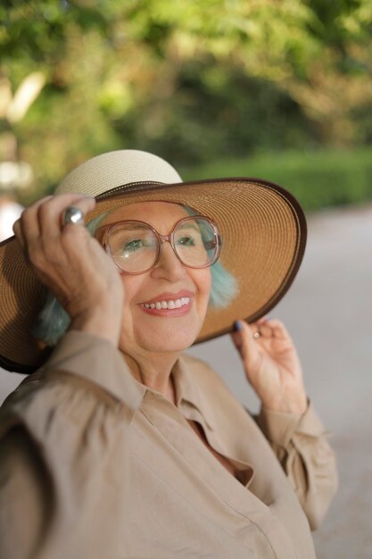 Senior woman with hat sonriendo à l'heure d'or