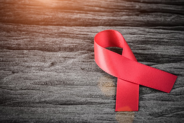 Photo sensibilisation au ruban rouge sur un fond en bois pour la campagne de la journée mondiale du sida