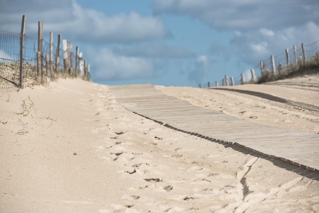 Sentier en bois à travers les dunes de la plage de l'océan dans l'ouest de la France. Mise au point sélective