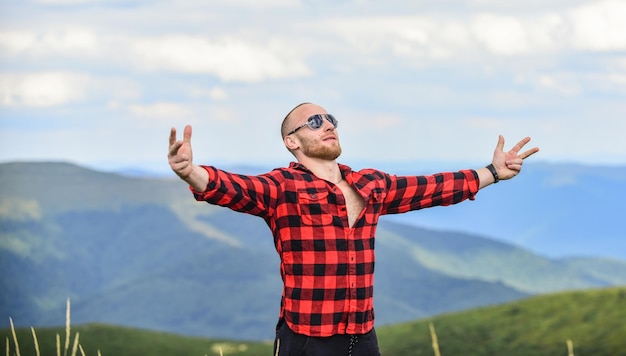 Sentiment de liberté campagne concept agriculteur sur rancho voyage aventure hipster mode homme sur paysage de montagne camping et randonnée sexy macho homme en chemise à carreaux cowboy au chapeau en plein air