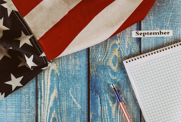 Septembre mois de l'année civile États-Unis d'Amérique drapeau du symbole de la liberté et de la démocratie avec bloc-notes vide et stylo sur la table en bois