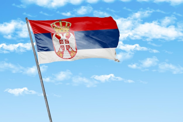 serbie drapeau ondulant en 3D sur un bleu ciel avec une image d'arrière-plan nuageux
