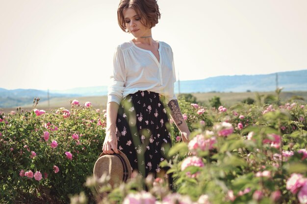 Série de fleurs temps libre de l'été Provence livres lisant au coucher du soleil pour une bouteille de vin rouge jeune femme marchant près de rosiers en fleurs