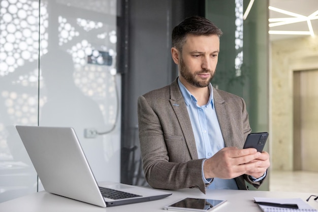 Photo sérieux concentré homme d'affaires mature pensant la lecture en ligne des réseaux sociaux expérimenté mature