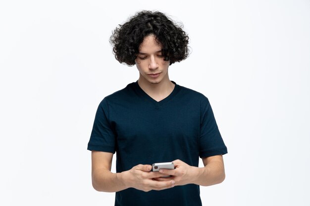 Sérieux jeune bel homme à l'aide de son téléphone portable isolé sur fond blanc