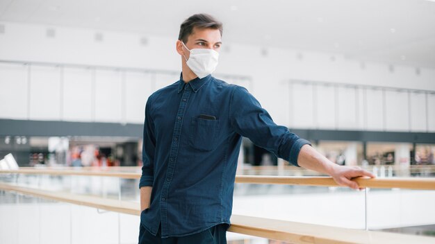 Sérieux jeune homme dans un masque de protection en regardant la ville déserte. photo avec copie de l'espace