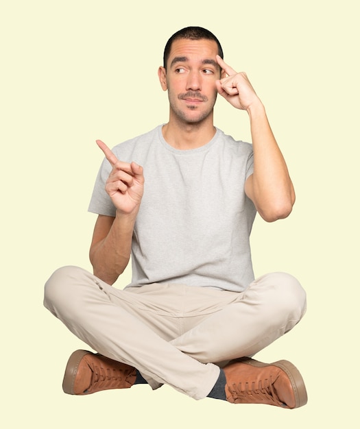 Sérieux jeune homme faisant un geste de concentration