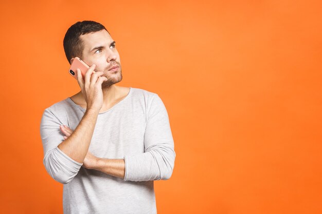 Sérieux jeune homme parlant sur mobile