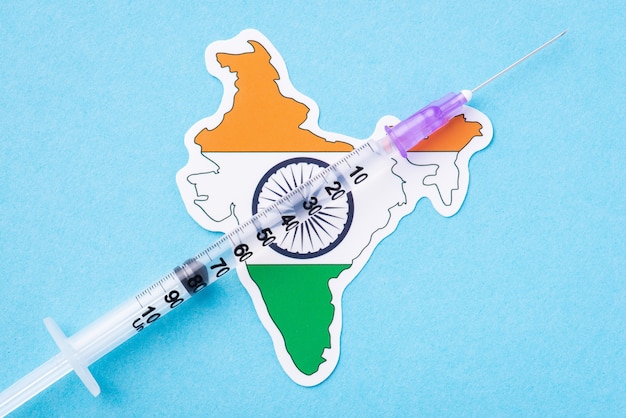 Seringue avec un certain vaccin de traitement médical sur le drapeau de l'Inde