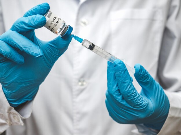 Seringue et flacon d'injection entre les mains d'un médecin. Gros plan, à l'intérieur. Lumière du jour, photo de studio. Concept de soins de santé