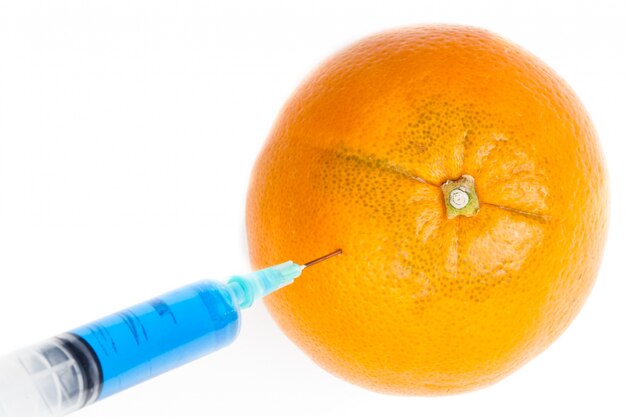 Seringue injectant dans une orange