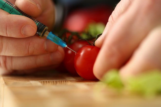 seringue à l'intérieur de la tomate cerise