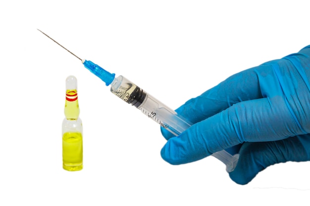Seringue avec médicament dans la main d'un médecin dans un gant bleu et une bouteille de médicament, gros plan isolé sur fond blanc