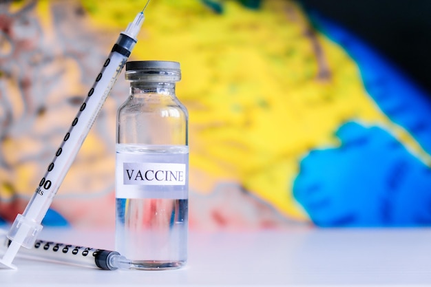 Photo seringues ampoules covid vaccin sur une carte du monde combattre le coronavirus sarcov pandémie coronavirus nco...