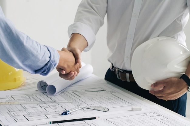 serrant la main d'un ingénieur de construction ou d'un architecte de collaboration discuter d'un plan
