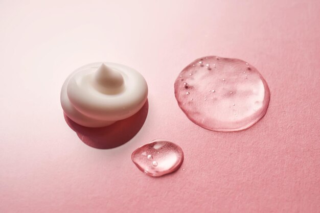 Un sérum de gel et une crème sur un fond rose