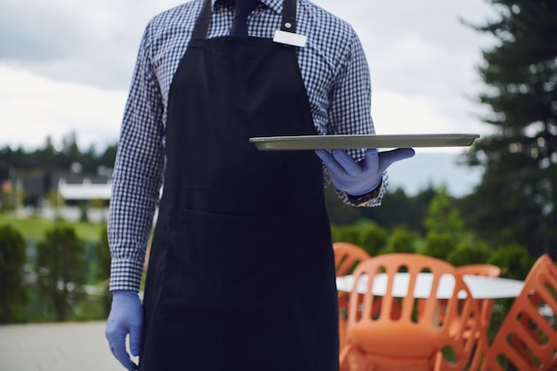 un serveur dans un masque de protection médicale sert le café au restaurant pendant la pandémie de coronavirus représentant un nouveau concept normal