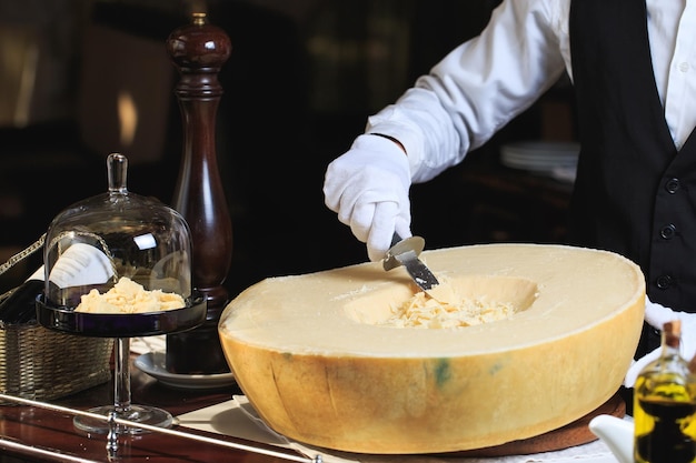 Le serveur découpe des morceaux de parmesan