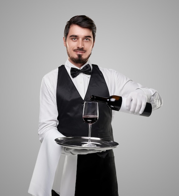 Serveur élégant servant du vin au restaurant